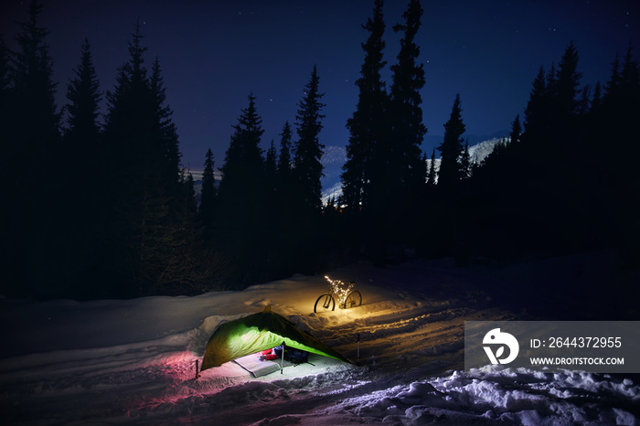 Bicycle with Christmas lights and tent at night