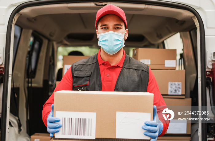 Portrait of delivery man wearing face protective mask for coronavirus spread prevention - Courier at work during covid 19 pandemic time