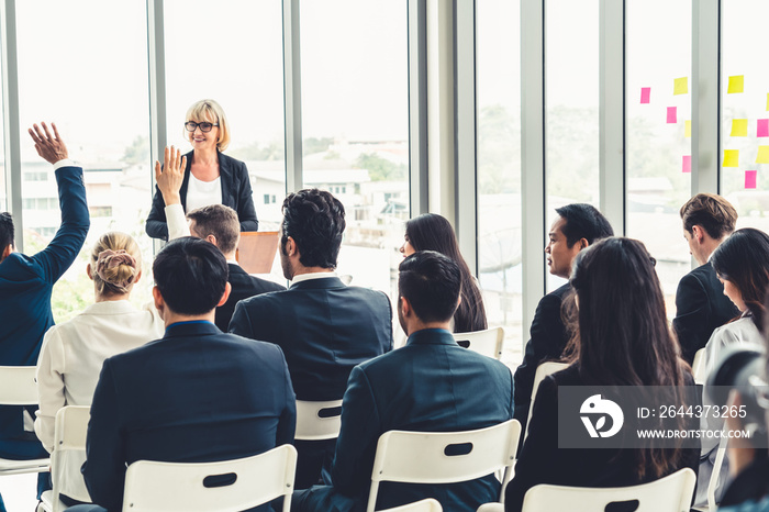 Group of business people meeting in a seminar conference . Audience listening to instructor in employee education training session . Office worker community summit forum with expert speaker .