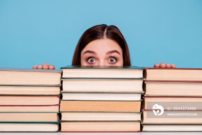 Close-up portrait of her she nice attractive intellectual smart clever brainy stunned girl hiding behind book shelf at work place station isolated over bright vivid shine blue background