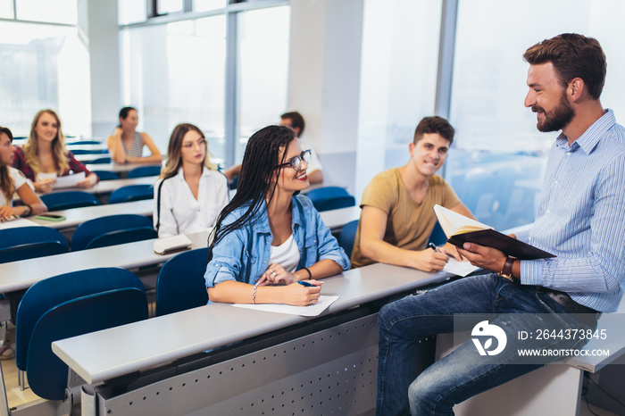 Young students listening to professor in the classroom on college