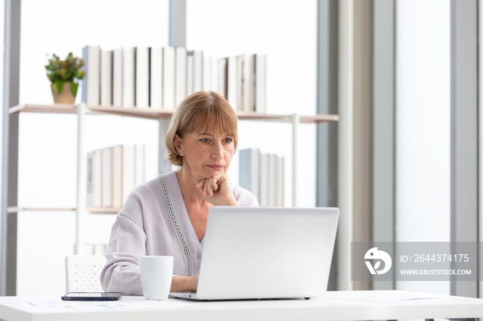 senior woman using laptop computer and serious at work