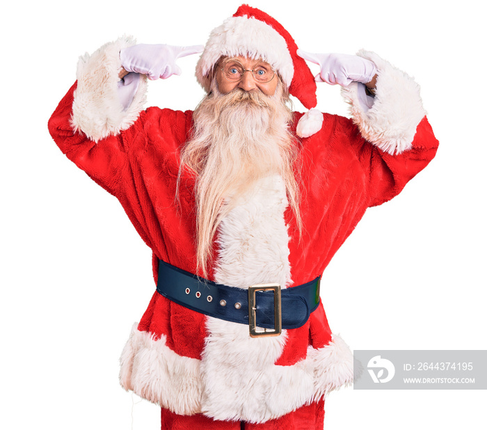 Old senior man with grey hair and long beard wearing traditional santa claus costume smiling pointing to head with both hands finger, great idea or thought, good memory