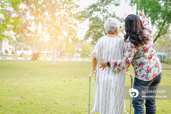 Doctor help and care Asian senior or elderly old lady woman use walker with strong health while walking at park in happy fresh holiday. .