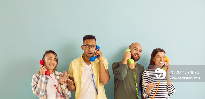 Diverse group of happy people talking on fixed line telephones. Studio portrait of four different young multiracial males and females calling friends and sharing news over phone. Communication concept