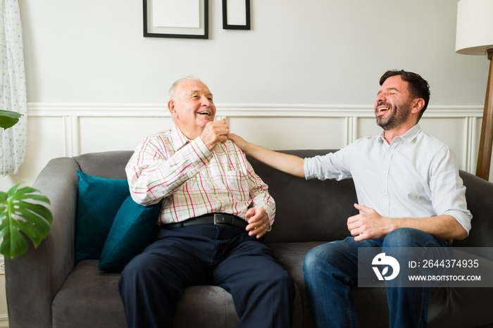 Excited elderly father and son having a fun chat and laughing