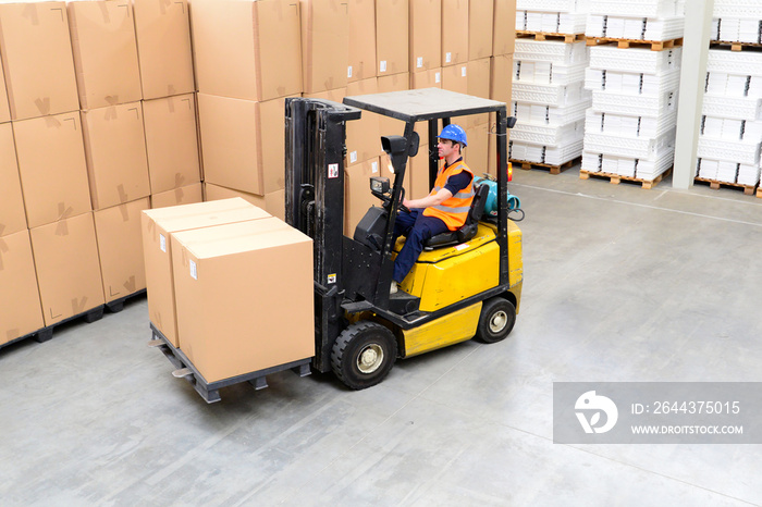 Gabelstaplerfahrer mit Kisten fährt in einer Lagerhalle Waren // Forklift truck drivers in a warehouse transported goods