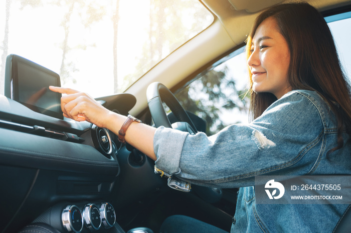 Closeup image a beautiful woman using and pointing finger at navigation screen while driving car