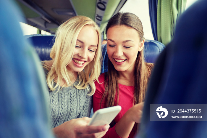 happy young women in travel bus with smartphone