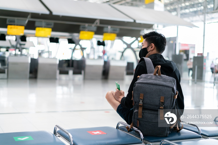 Asian male wearing face mask traveler giving boarding pass and passport to customer check in officer at service counter airport.Man wearing face mask when traveling to prevent coronavirus pandemic.