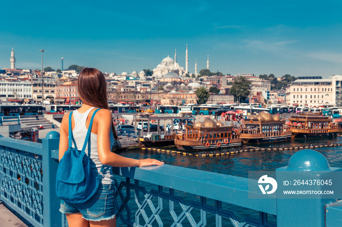 Young tourist woman on Galata bridge, Golden Horn bay, Istanbul. Panorama cityscape of famous tourist destination Bosphorus strait channel. Travel landscape Bosporus, Turkey, Europe and Asia.