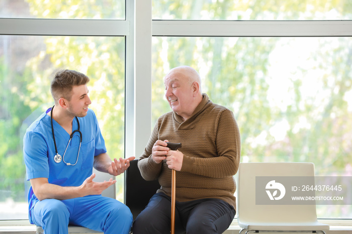 Medical worker with senior man in nursing home