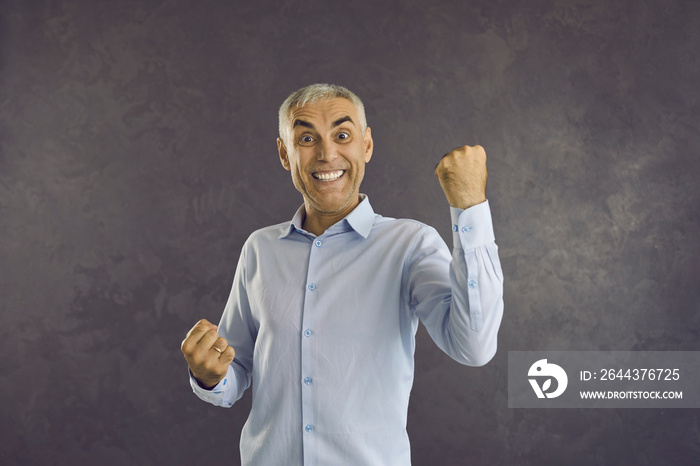 Portrait of overjoyed middle-aged man isolated on black studio background feel euphoric celebrate success win victory. Excited male winner triumph smile with good news. Celebration, luck concept.