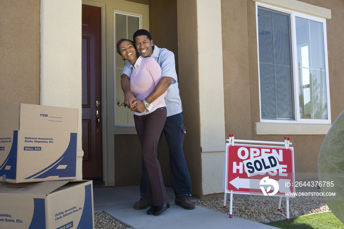 Full length portrait of a happy African American couple embracing each other at doorway