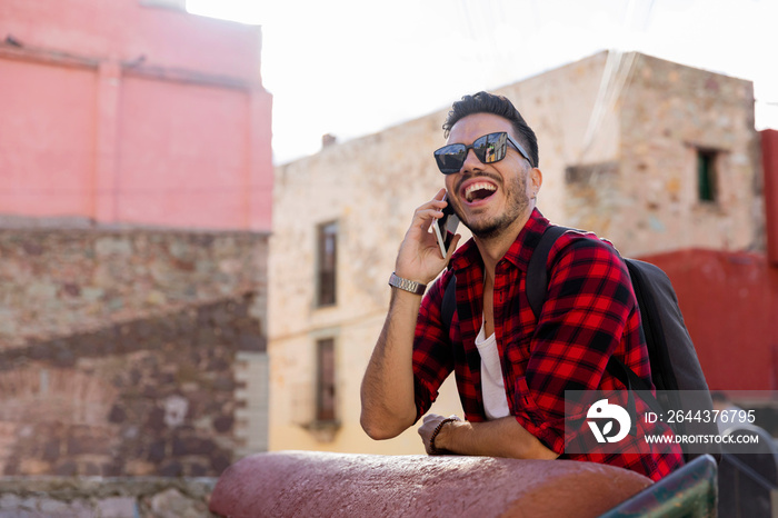 Mexican student in Guanajuato city, exploring a colorful village with a checked shirt.