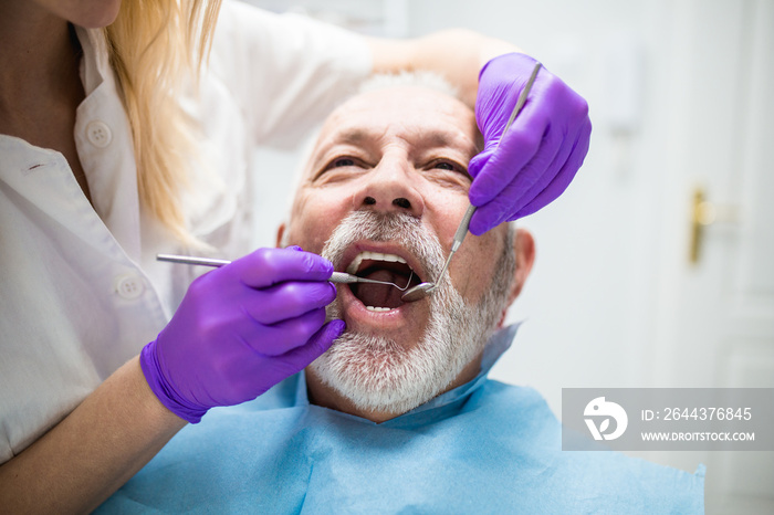 Senior man having dental treatment at dentist’s office.