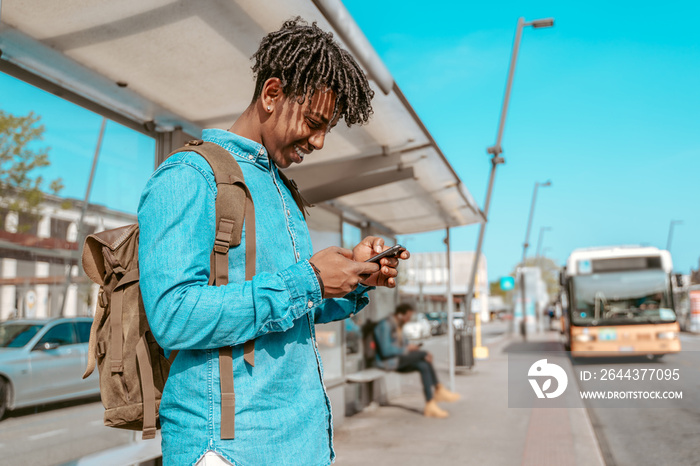 Guy looking at smartphone standing sideways to camera