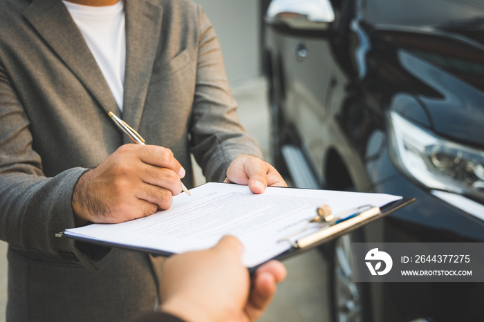 A young business man signs a luxury car leasing contract And sign a car insurance purchase contract on the documents according to the agreement