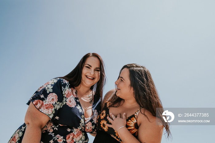 2 women smile and laugh with each other