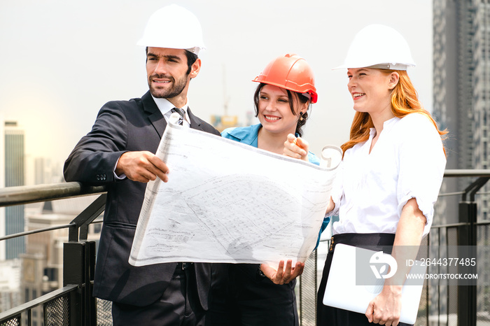 Engineer man and architect coworker standing outdoors on rooftop of construction site looking at blueprint for apartment, housing development. Maintenance building contractor discussion with teamwork