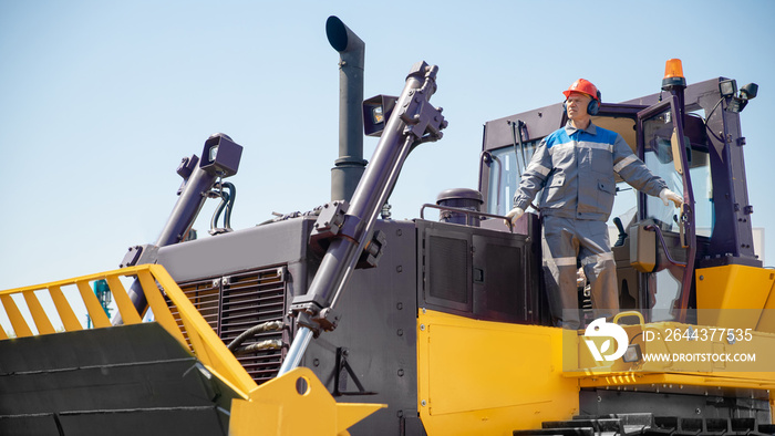 Portrait of industry mechanical worker on bulldozer on open pit mine