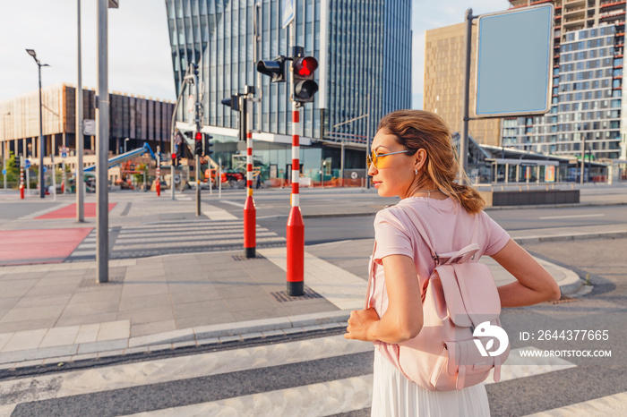 The girl is going to cross the road on a prohibiting red light. Road traffic safety concept