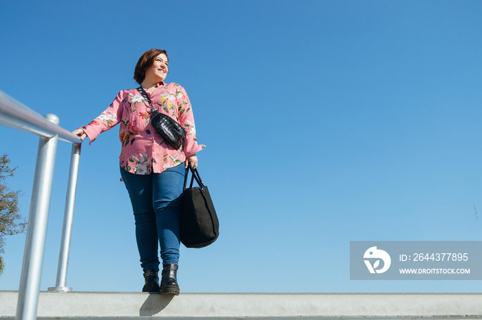 young caucasian argentinian woman standing on edge of stairs outdoors smiling looking to one side