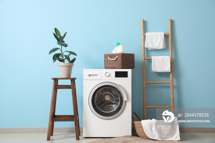 Interior of stylish laundry room with washing machine, stool and ladder