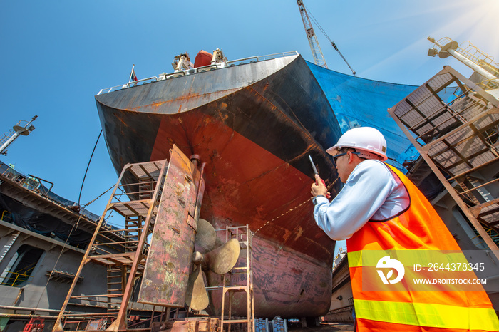 Stevedore, controller, Port Master, surveyor inspect the bulk head of commercial cargo ship in floating dry dock, recondition of overhaul repairing and painting, sand blasting in dry dock yard