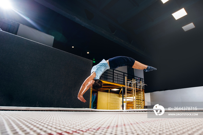 Young woman sportsman fitness jumping on club trampoline