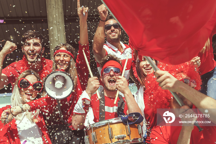 group of fans dressed in red color watching a sports event