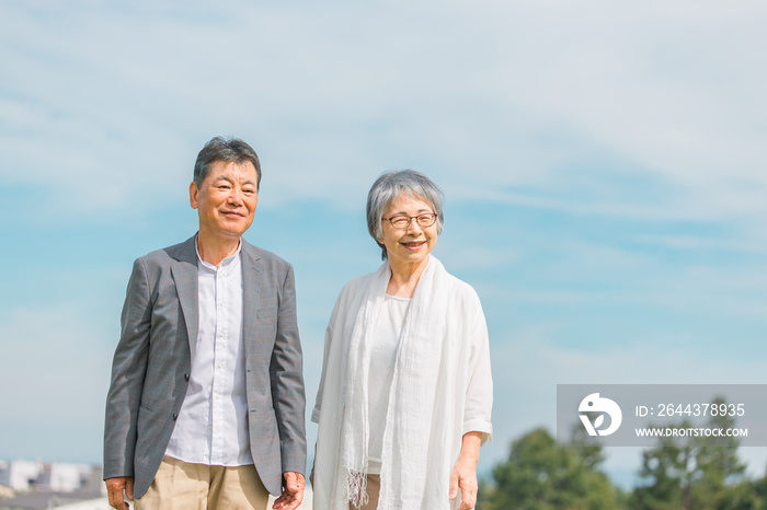 街を話しながら歩く日本人の高齢者夫婦（シニア・男女）