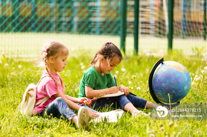 Young people and education, two little girls and boys reading book in city park