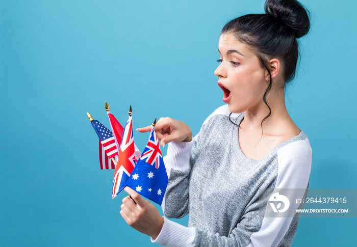 Young woman with learn English theme with the flags of English speaking countries on a blue background