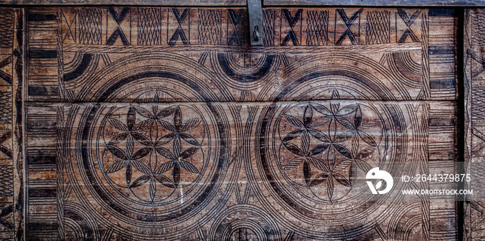 Vintage wooden element of carved ornament on a chest in the shape of a flower of life.