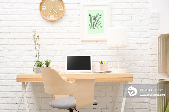 Workplace with laptop on desk in modern room