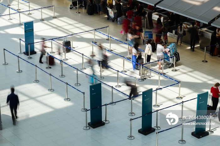 Abstract motion blurred image of people at the airport walking in line to their check in or departure gate