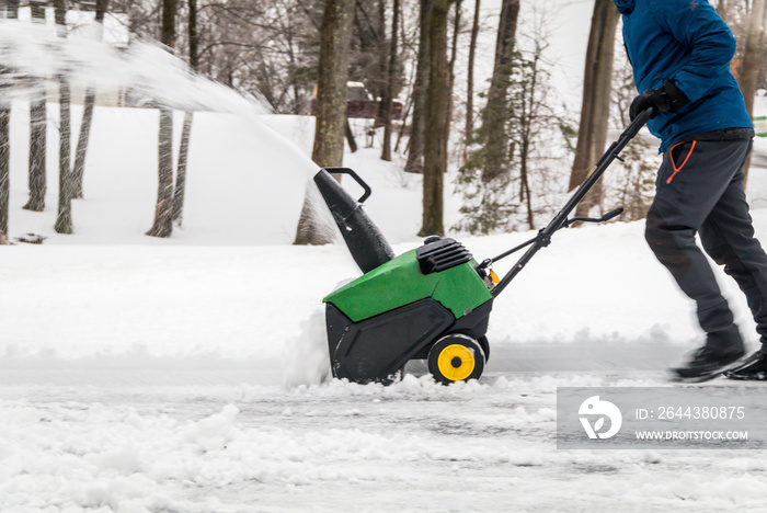 Snowblower in action being pushed after snowfall and ice on a cold winter day in rural NJ, USA