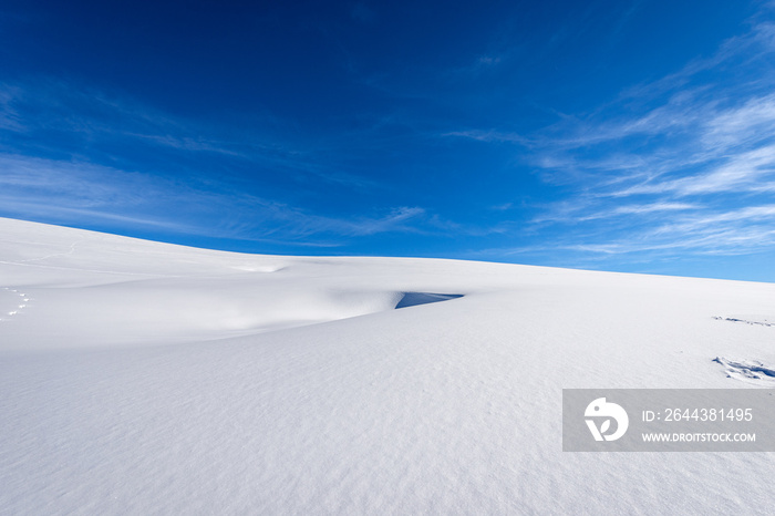 Close-up of a winter landscape with powder snow on blue sky with clouds. Lessinia Plateau (Altopiano della Lessinia), Regional Natural Park, Verona Province, Veneto, Italy, Europe.