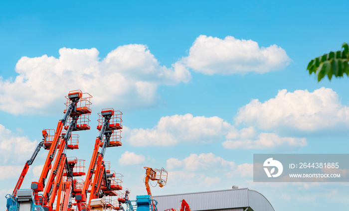 Articulated boom lift. Aerial platform lift. Telescopic boom lift against blue sky. Mobile crane parked at parking area for rent. Hydraulic boom lift at parking lot of crane dealership sale office.