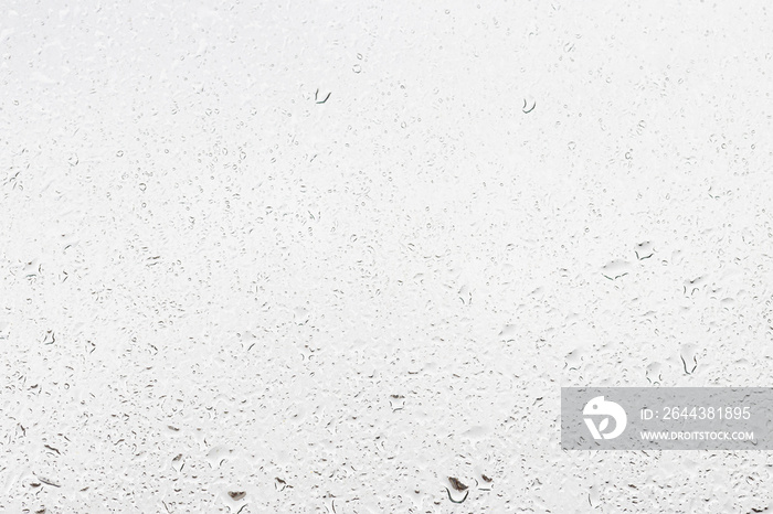 Rain drops on window glasses surface with gray sky background . Natural backdrop of raindrops. Abstract overlay for design. The concept of rainy weather.