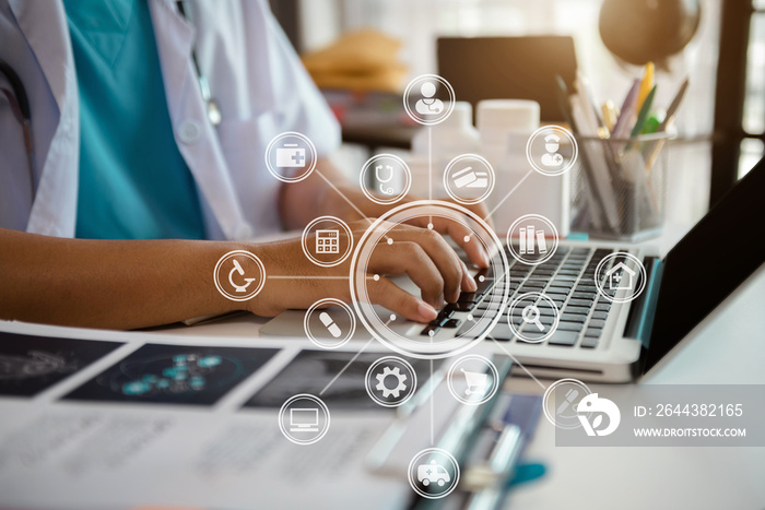 Doctor working on laptop computer and medical stethoscope on clipboard on desk, electronics medical record system EMRs concept.