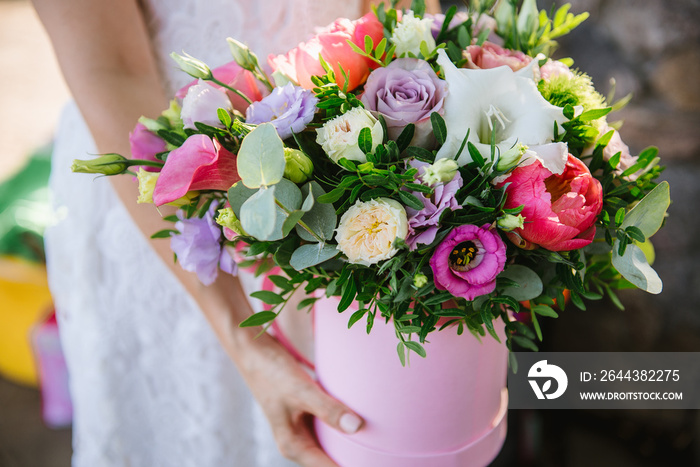 girl holding beautiful mix flower bouquet in round box