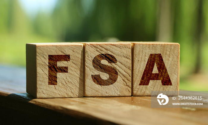 Flexible spending account FSA written on a wooden cubes. Financial concept