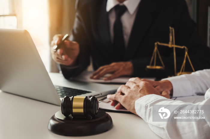 Business and lawyers discussing contract papers with brass scale on desk in office. Law, legal services, advice,  justice and law concept .