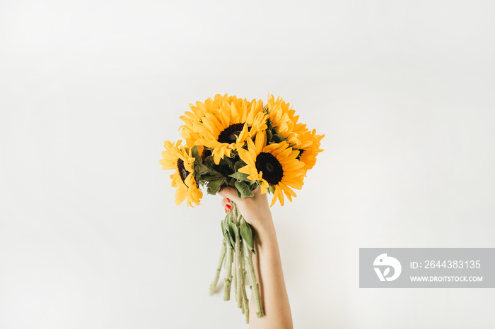 Sunflowers bouquet in female hands. Flat lay, top view summer floral hero header.