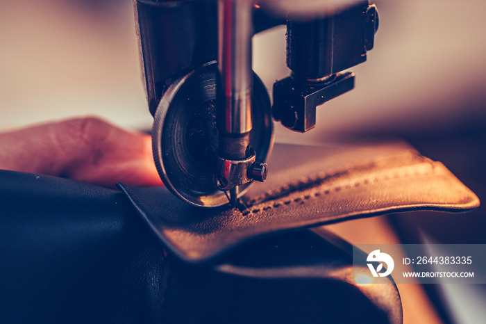 Shoemaker hands stitching a part of the shoe  in the handmade footwear industry