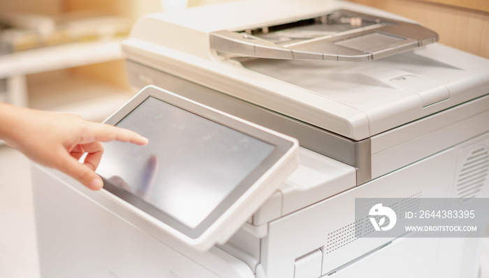 Female hand pressing the touchscreen monitor of the copy machine for copy a paper document, scanner document in the copy machine