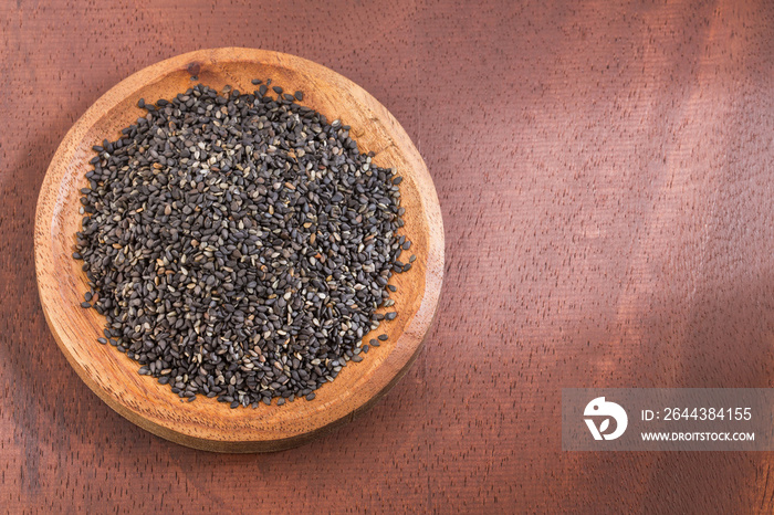 Black sesame seeds. Wooden bowl