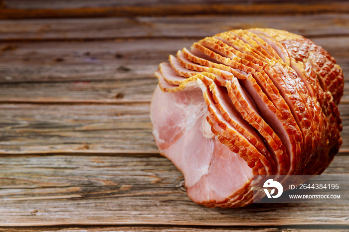 Delicious honey smoked pork ham on wooden background.